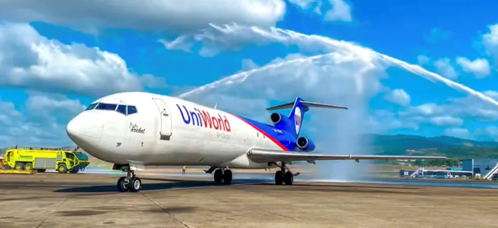 A UniWorld Air Cargo Boeing 727-200F receives a water cannon salute on the tarmac.