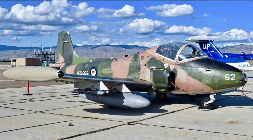 A Royal New Zealand Air Force BAC Strikemaster Mk.88 (NZ6362) in camouflage paint scheme parked on an airfield with mountains in the background.