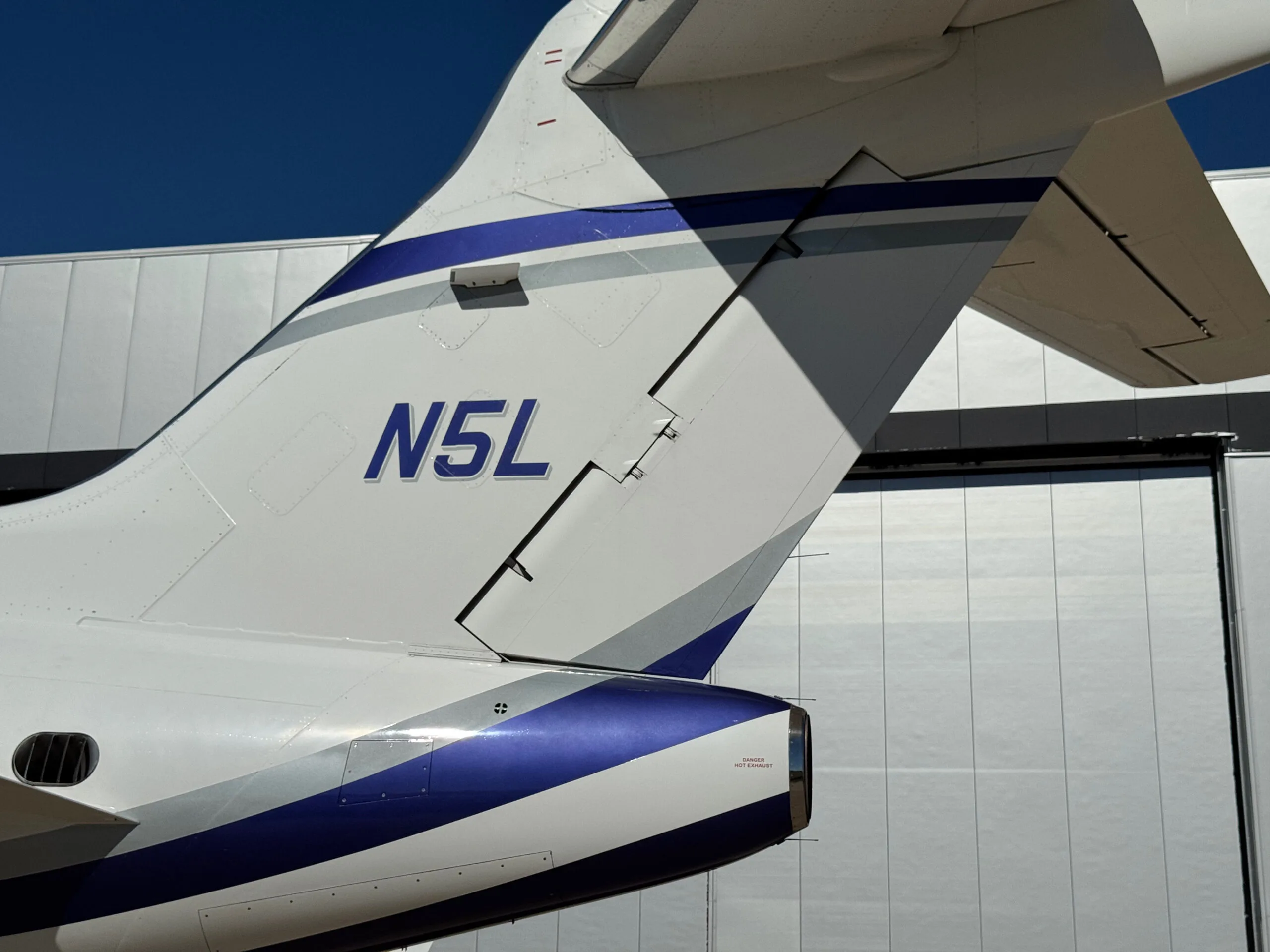 Close-up of the tail of the N5L business jet, showing the registration N5L and the blue and silver stripe livery.