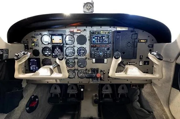 The cockpit instrument panel with dual yokes and various gauges and screens.