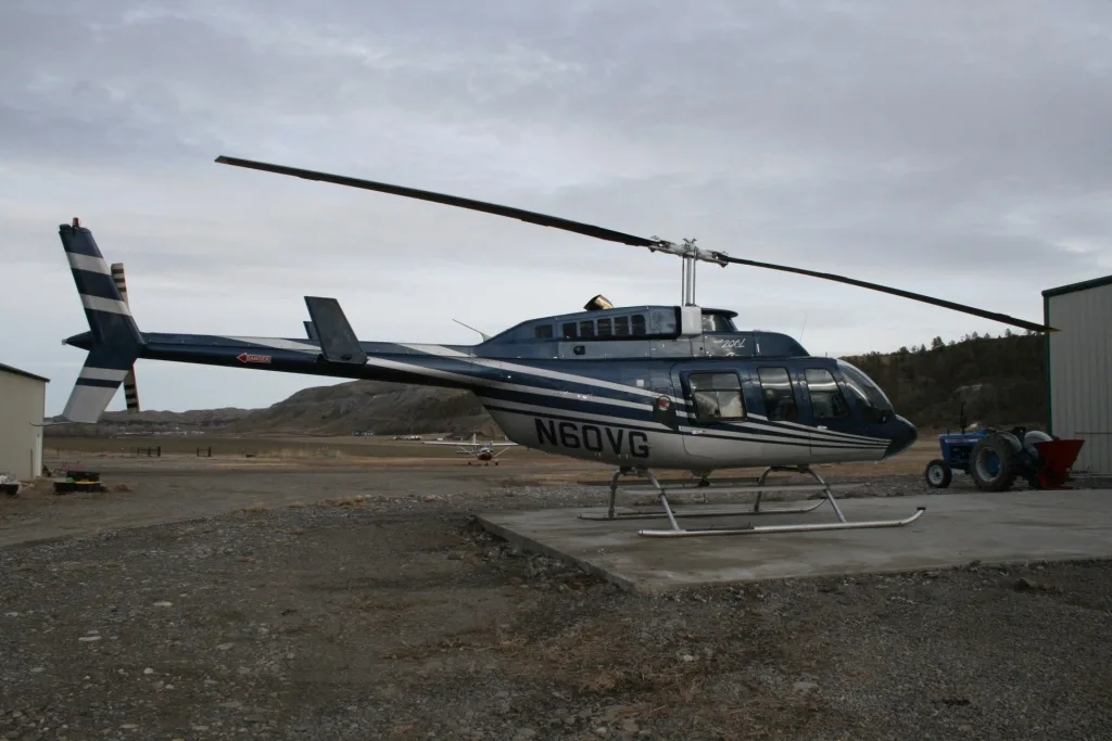 Close-up view of the lower instrument panel and cyclic/collective controls in a helicopter cockpit.