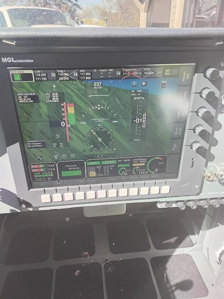A close-up view of a modern MGL digital flight display showing various aircraft parameters and a synthetic vision view.