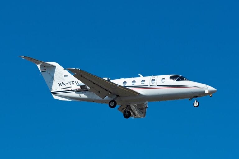 A white jet with gold accents parked on the tarmac.