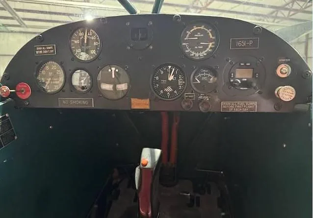 The instrument panel of a small aircraft features analog gauges and controls.