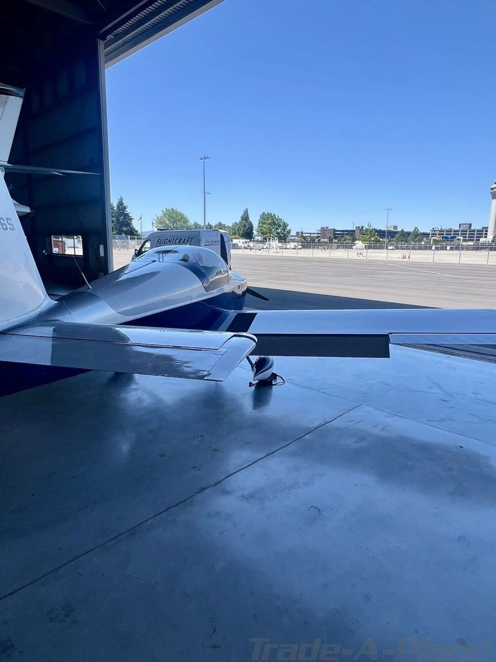 A side view of the aircraft with the hangar door open.