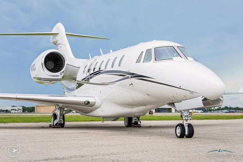 A three-quarter front view of the white Cessna Citation XLS+ business jet N448CX, highlighting its engines and paint scheme.