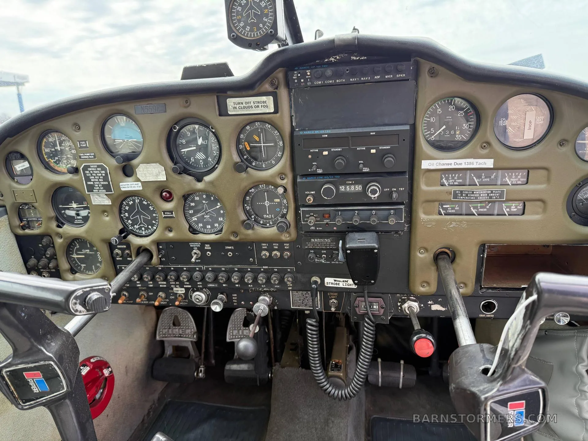 The instrument panel and controls of a small aircraft, featuring analog gauges and avionics.