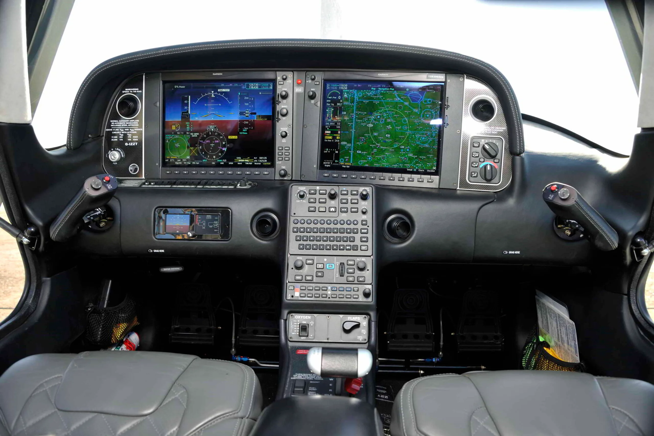 The detailed instrument panel of a Cirrus SR22T with dual Garmin screens displaying flight information and a map.