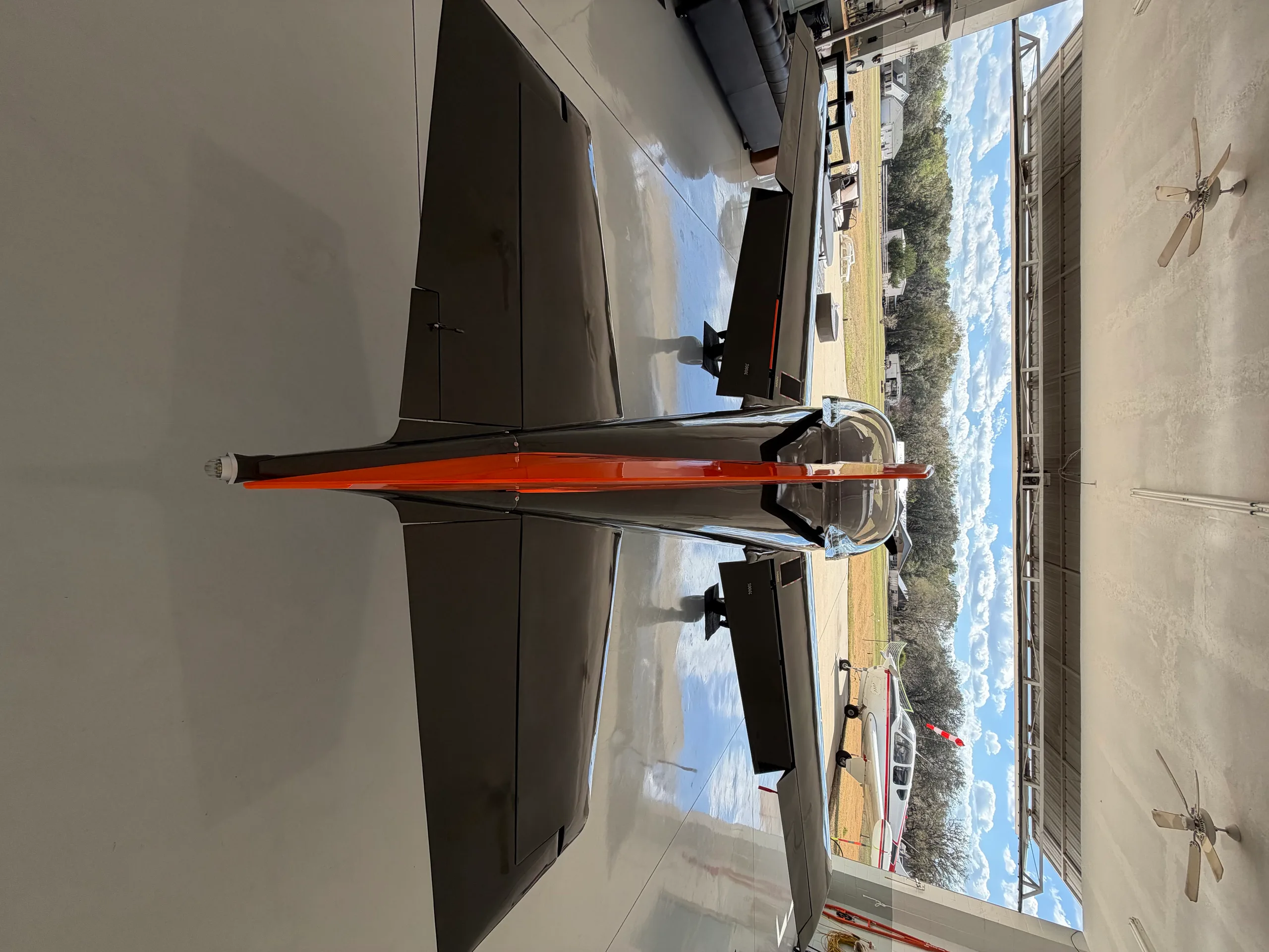 An overhead view of the black and orange checkered experimental aircraft, N7224A, parked inside a hangar.