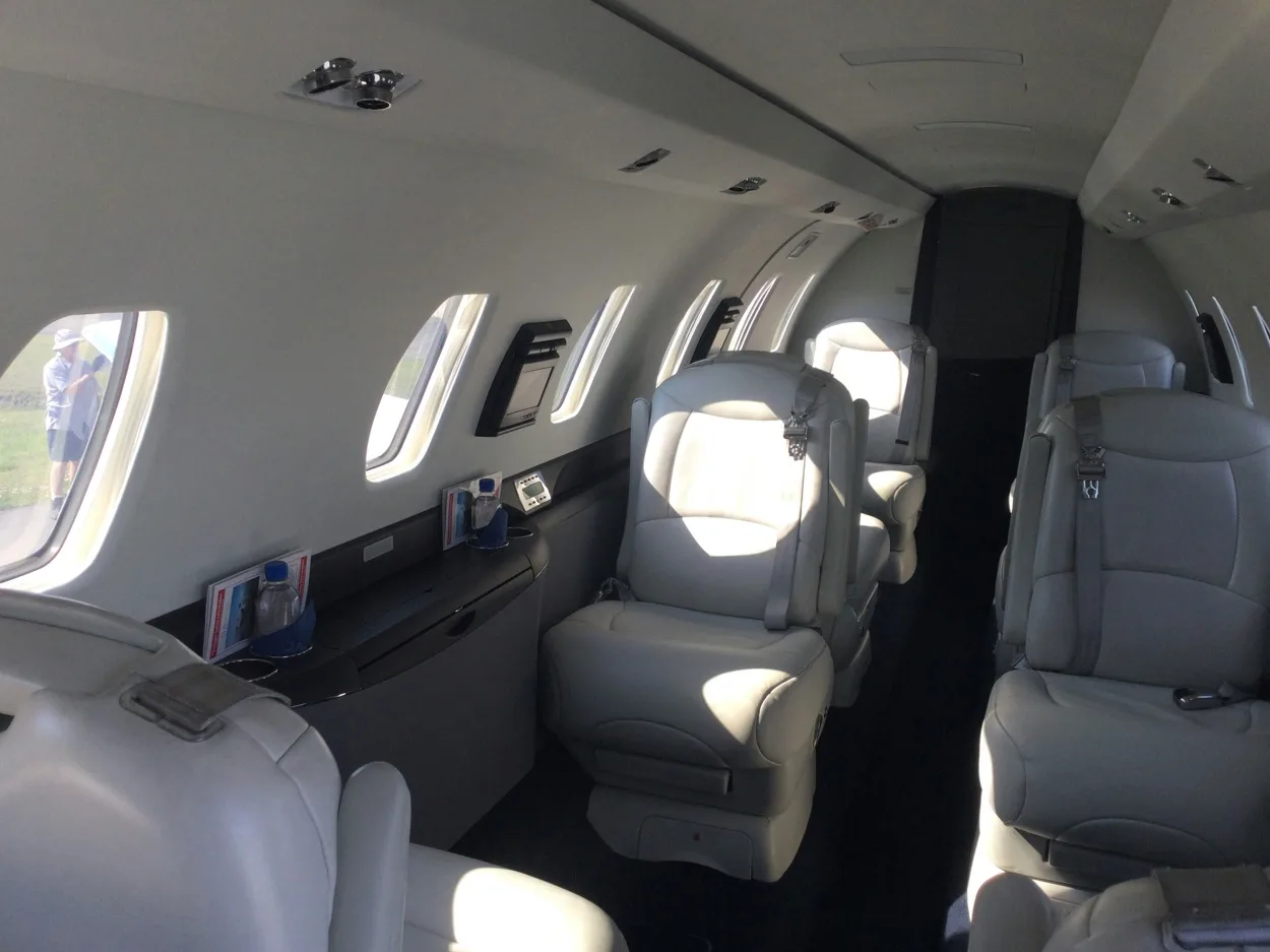 Aircraft cabin with light gray leather seats.