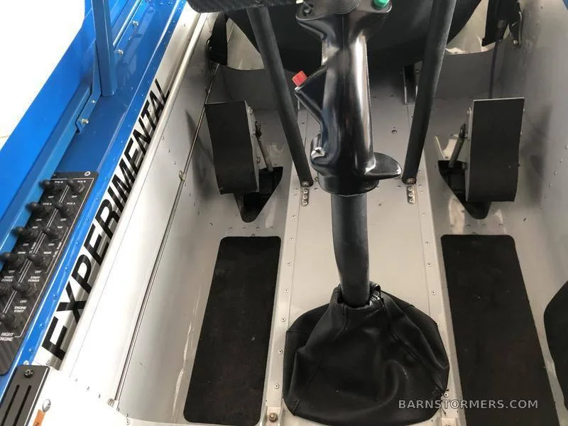 The interior of an aircraft showing the pilot's foot pedals, a central joystick, and a side panel labeled "EXPERIMENTAL".