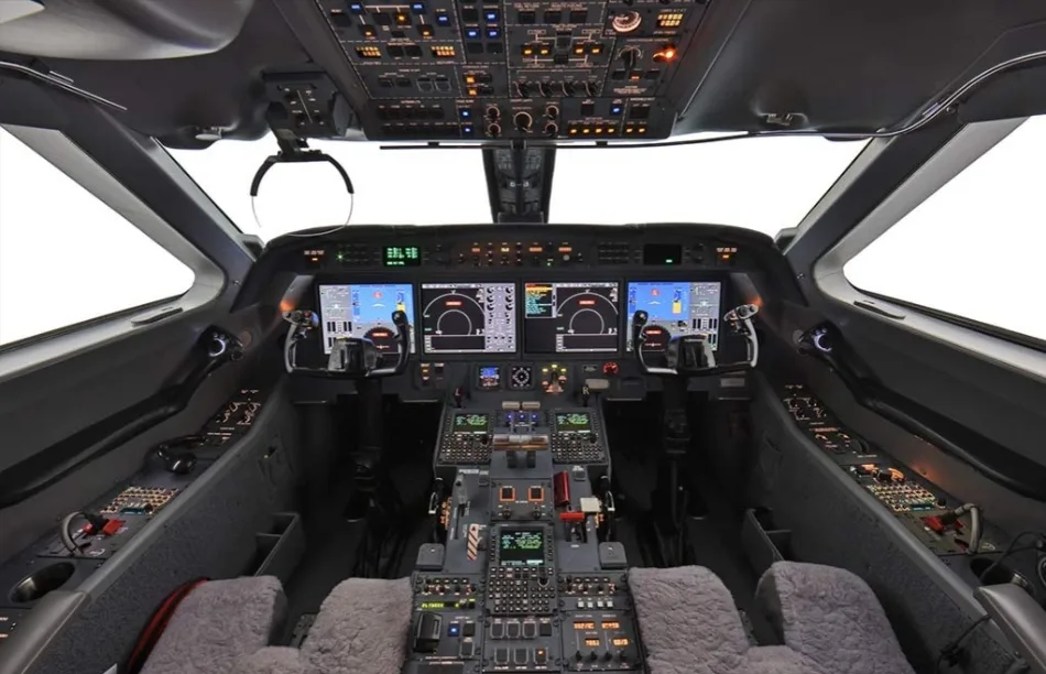The modern cockpit of a business jet, featuring multiple digital displays and a complex control panel.