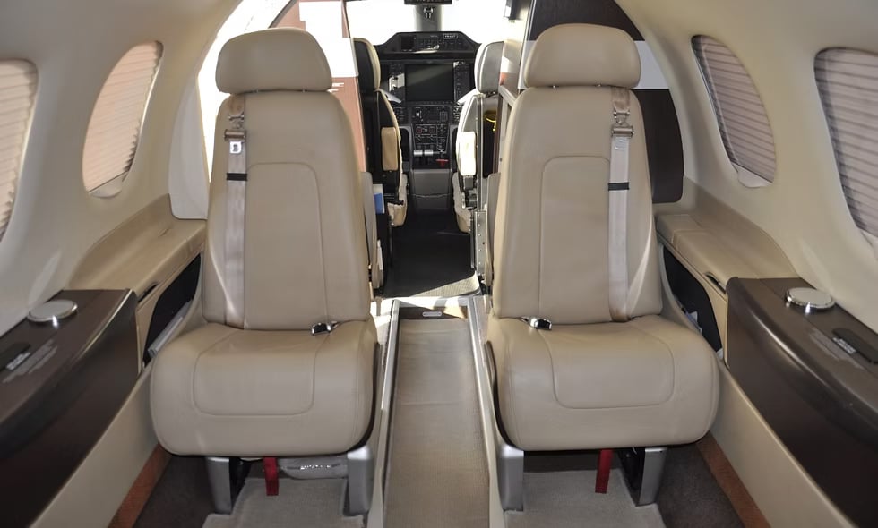 Interior view of the aircraft showing two seats with tables.
