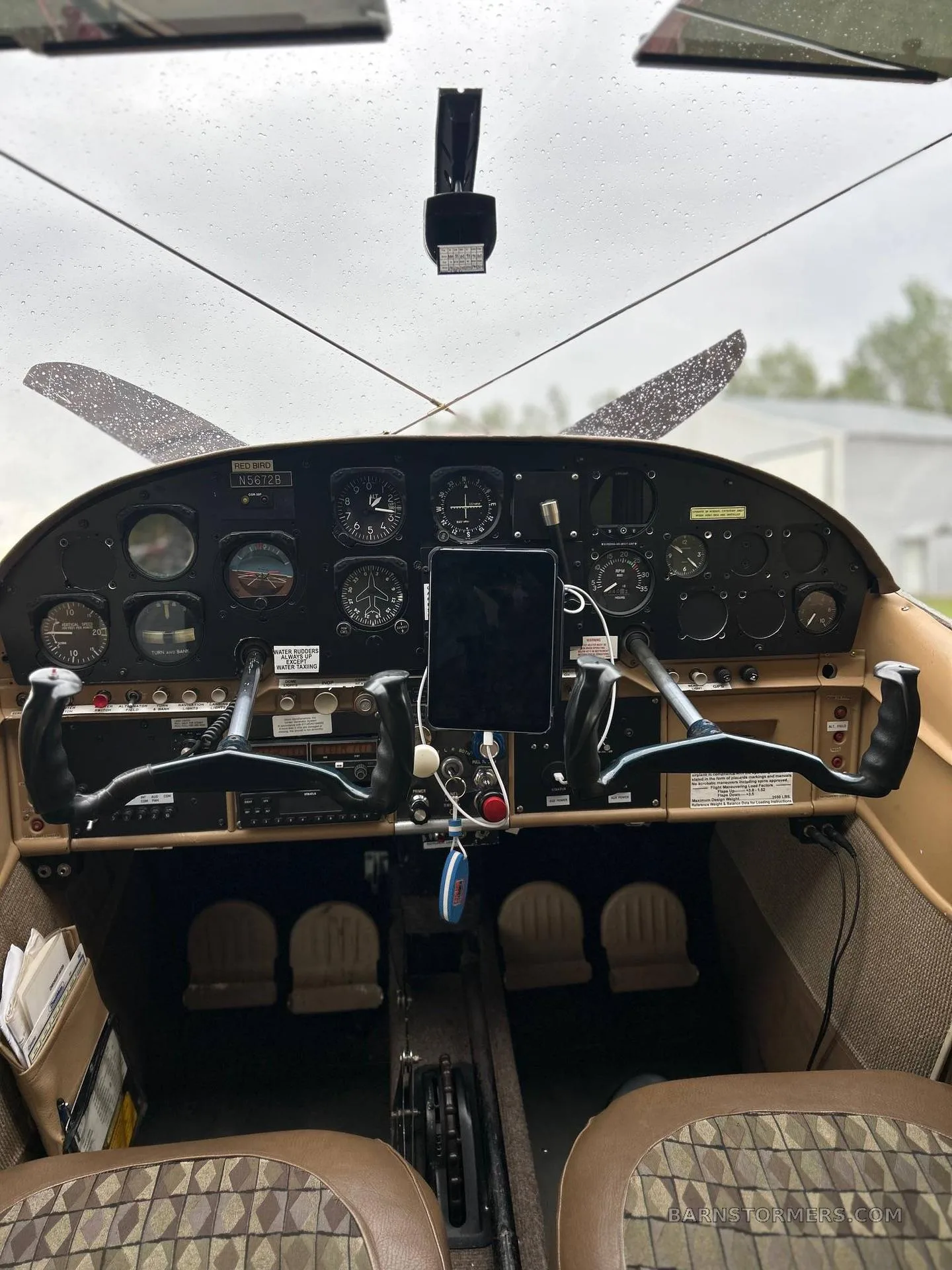 A view of the aircraft cockpit showing the instrument panel, yokes, and an iPad mounted.