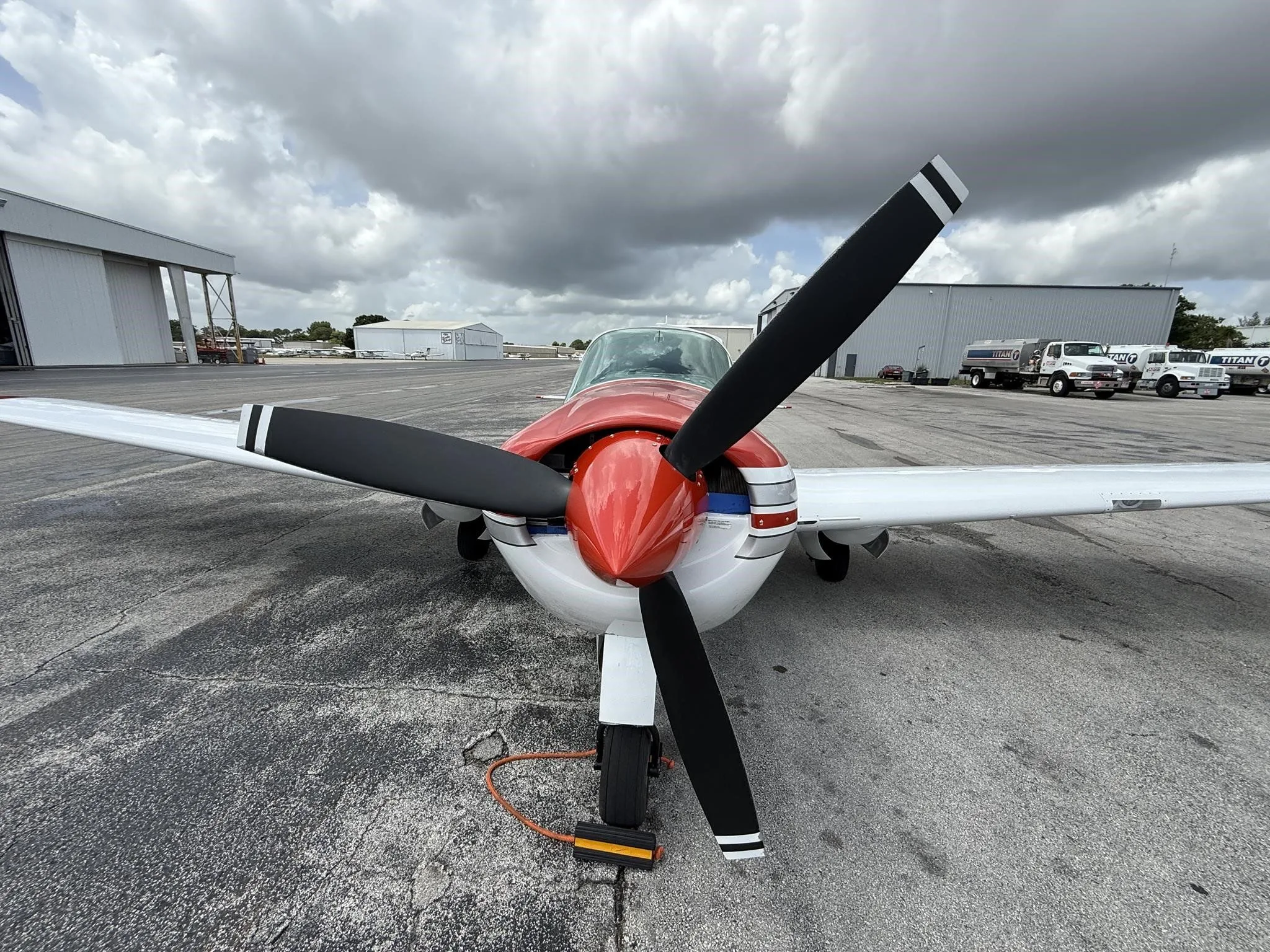 A head-on view of the white and red single-engine aircraft, N2667B, showing its propeller and red nose cone.