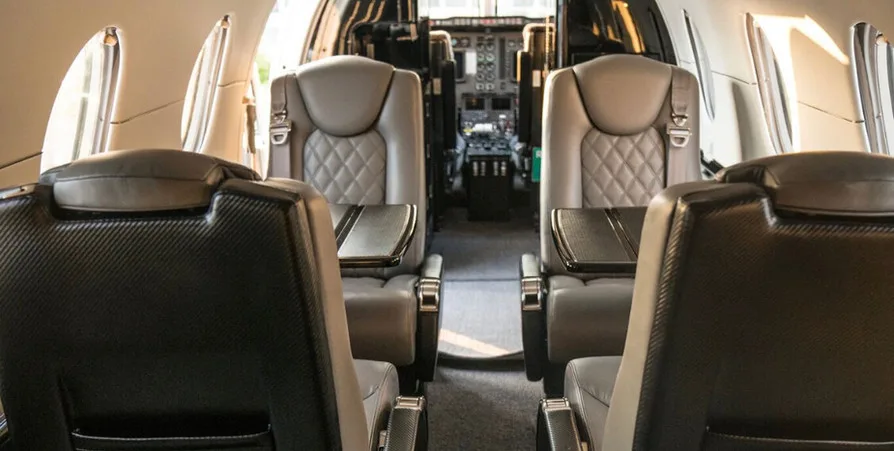 Interior view of the aircraft cabin showing leather seats and the cockpit.