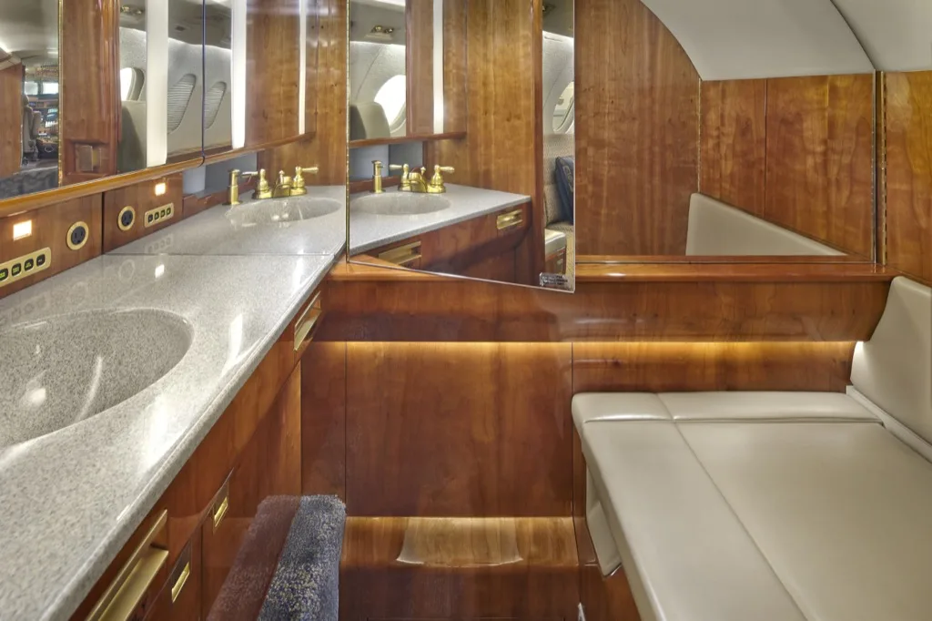 Hawker 850XP lavatory with wood trim and marble countertop.