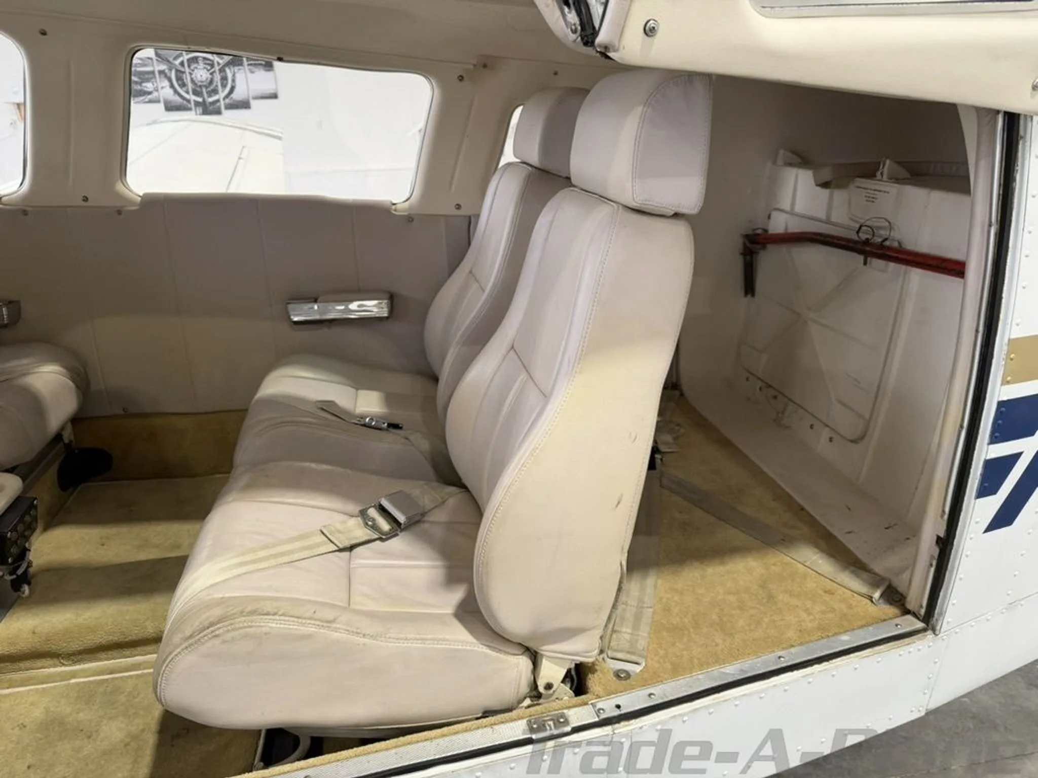 A close-up view of the light-colored rear cabin seats of a small aircraft.