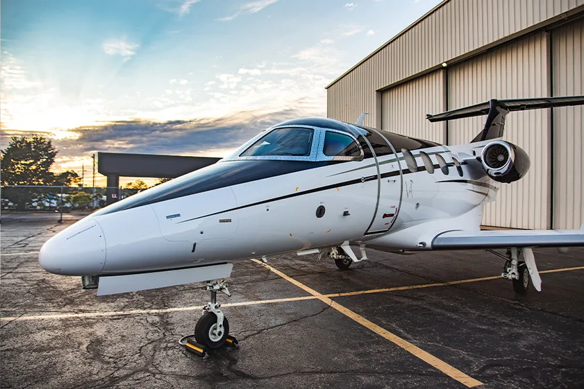 Close-up of a Cirrus Vision Jet with an open door parked on the tarmac.