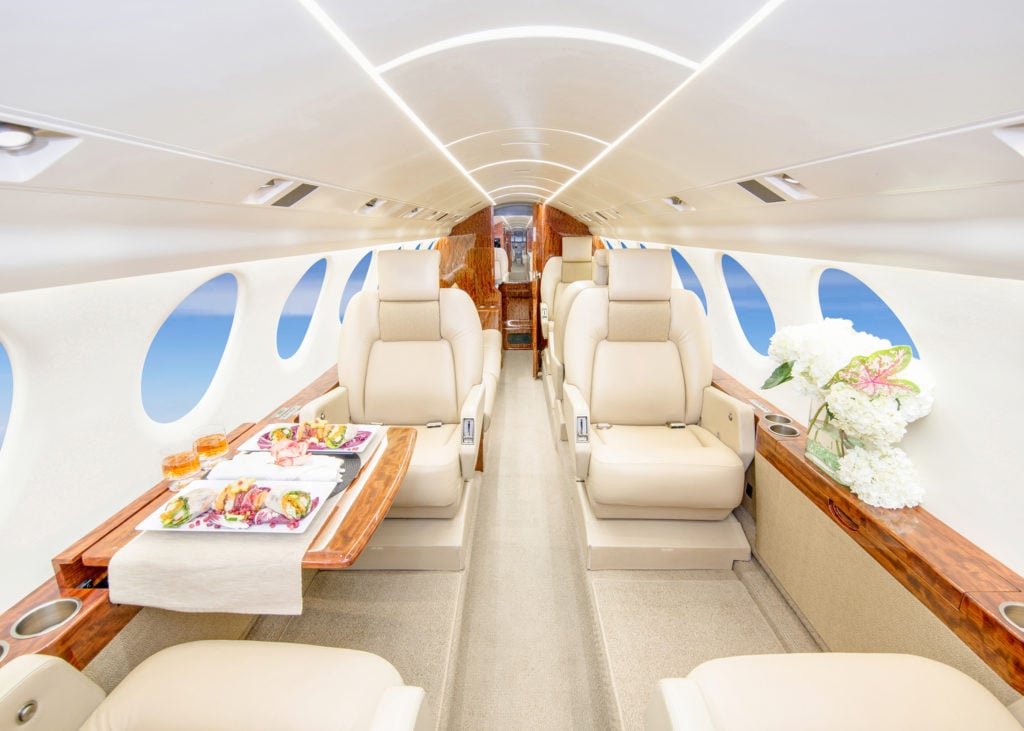 View of the interior cabin with cream-colored leather seats and a couch.