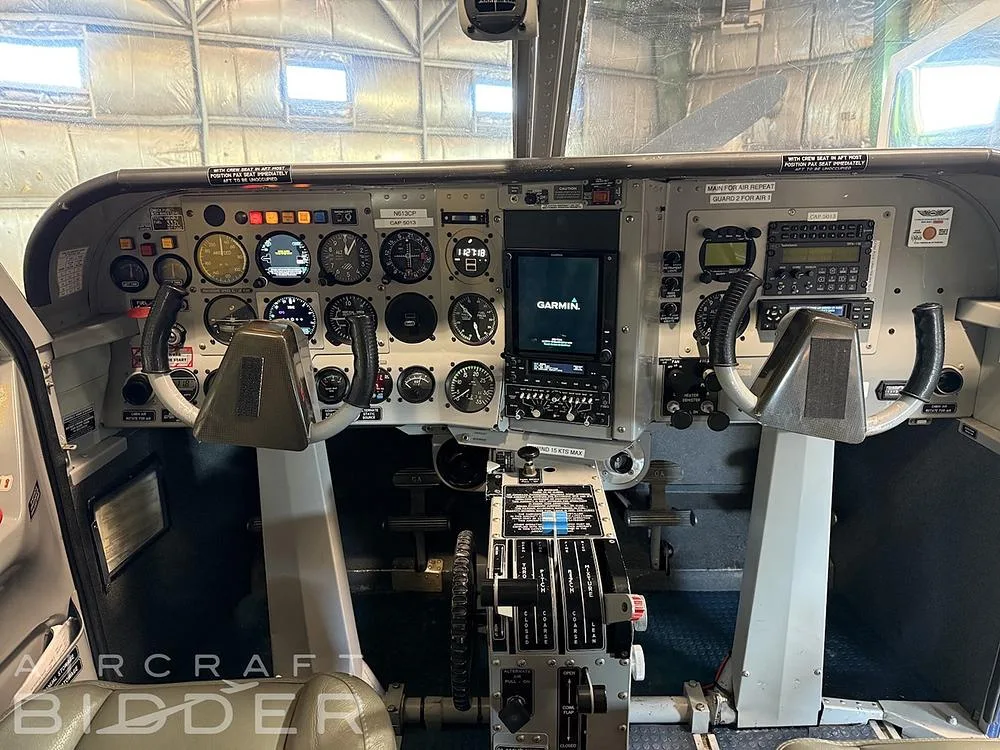 The cockpit of the aircraft, featuring a mix of analog gauges and a central Garmin digital display.
