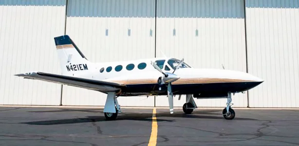 A Cessna 421 Golden Eagle aircraft parked in front of a hangar.