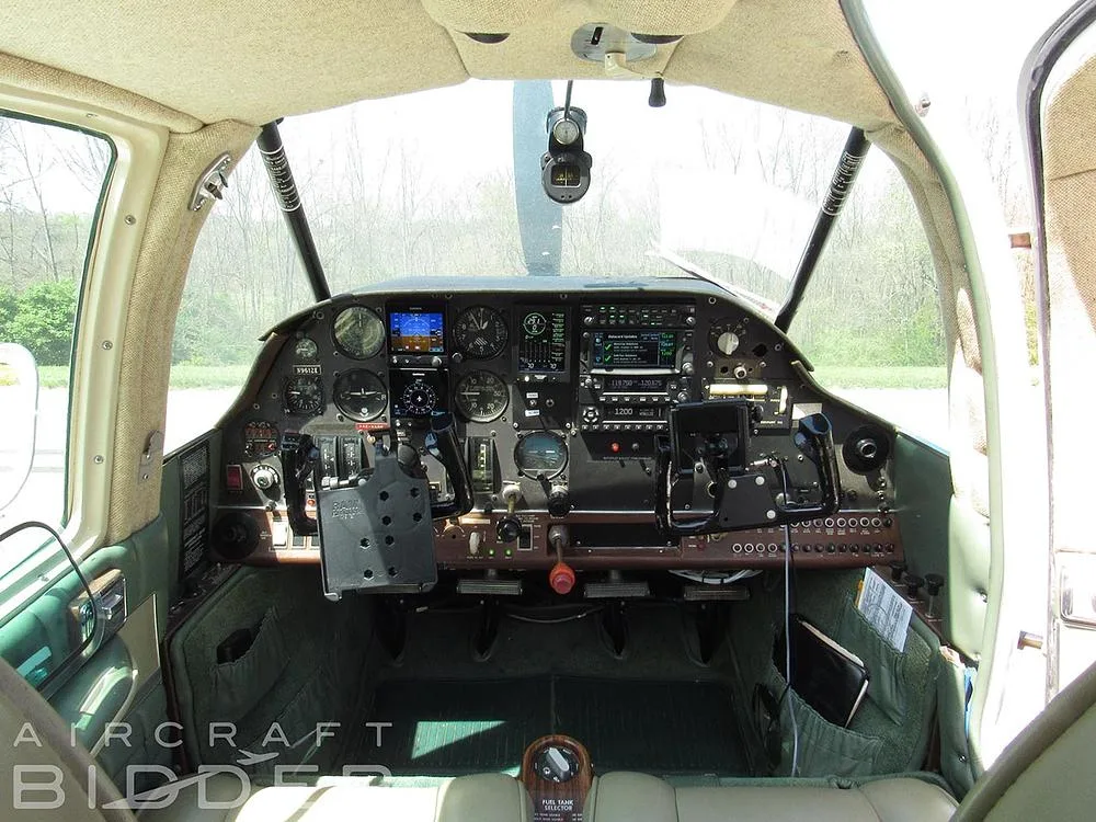 The cockpit of a single-engine aircraft, showing the instrument panel with various gauges, screens, and controls.