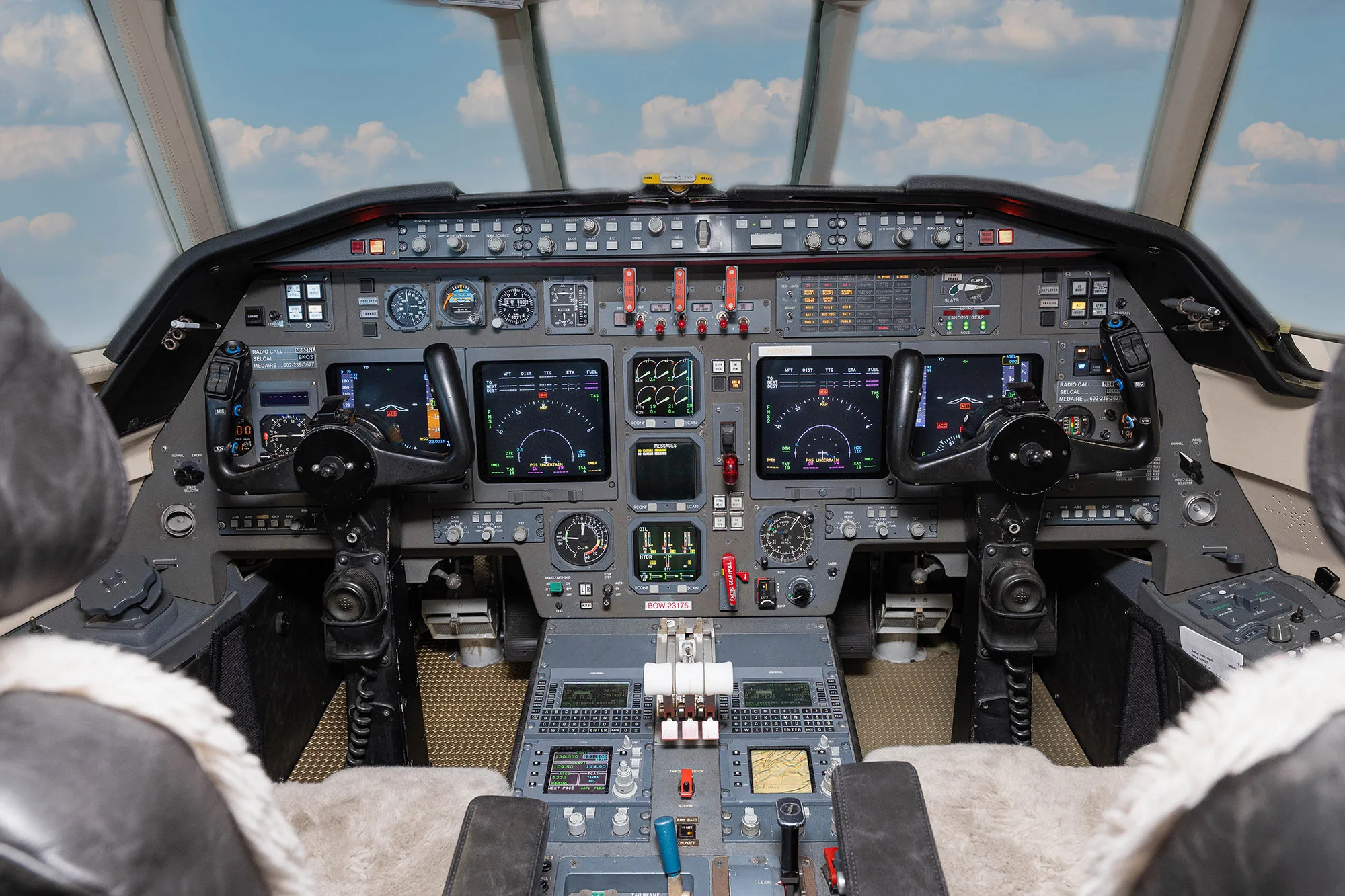 The cockpit of a Dassault Falcon 900EX business jet with multiple display screens and controls.