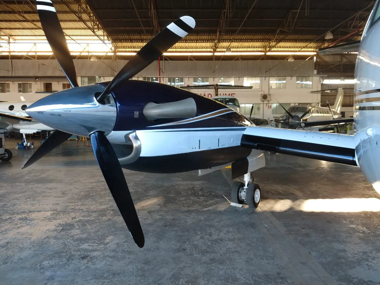 Close up of the propeller and engine cowling of a Beechcraft King Air 200 inside a hangar.