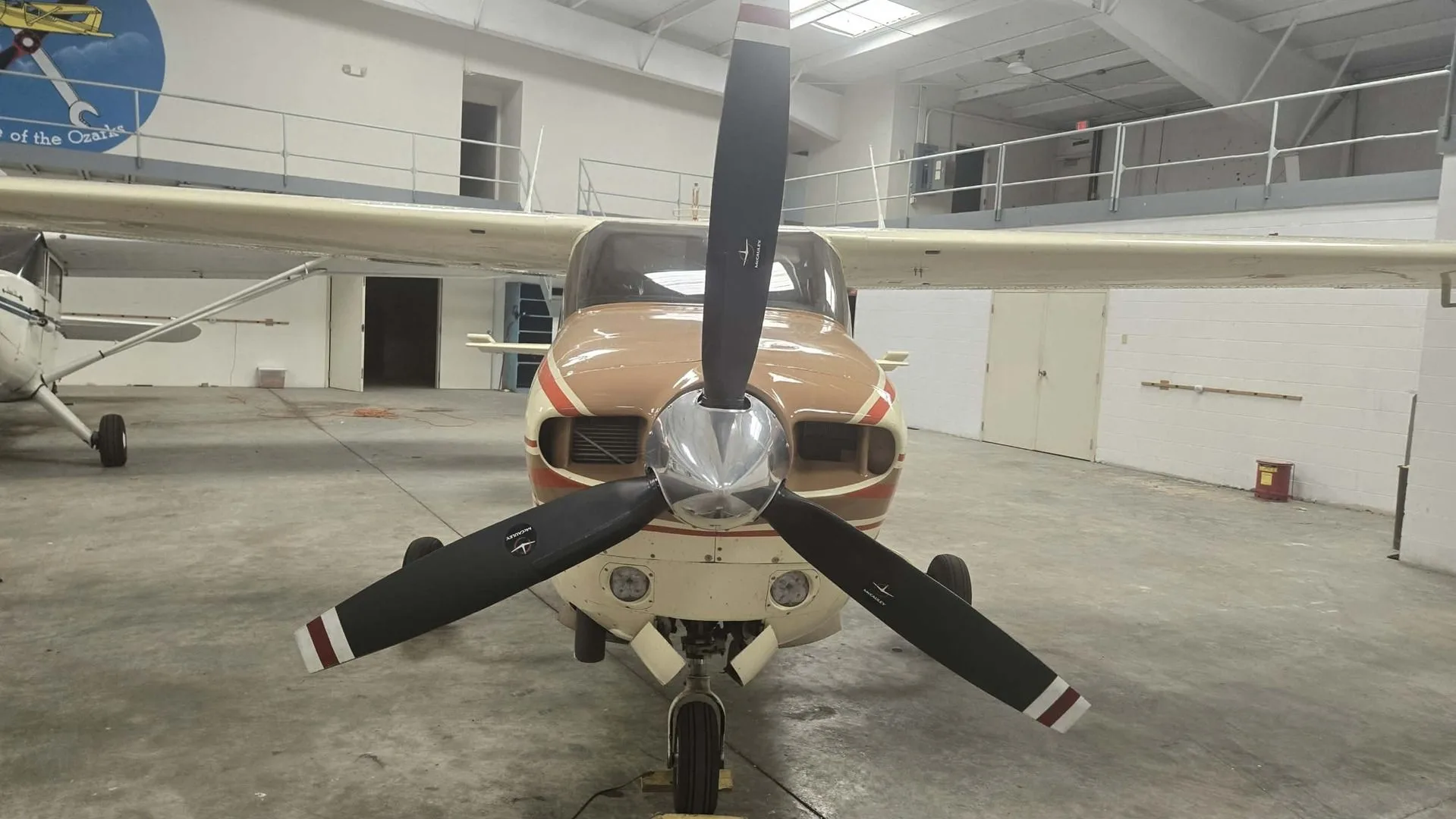 A head-on view of the N6170N aircraft, showing its propeller and brown nose, parked in a hangar.