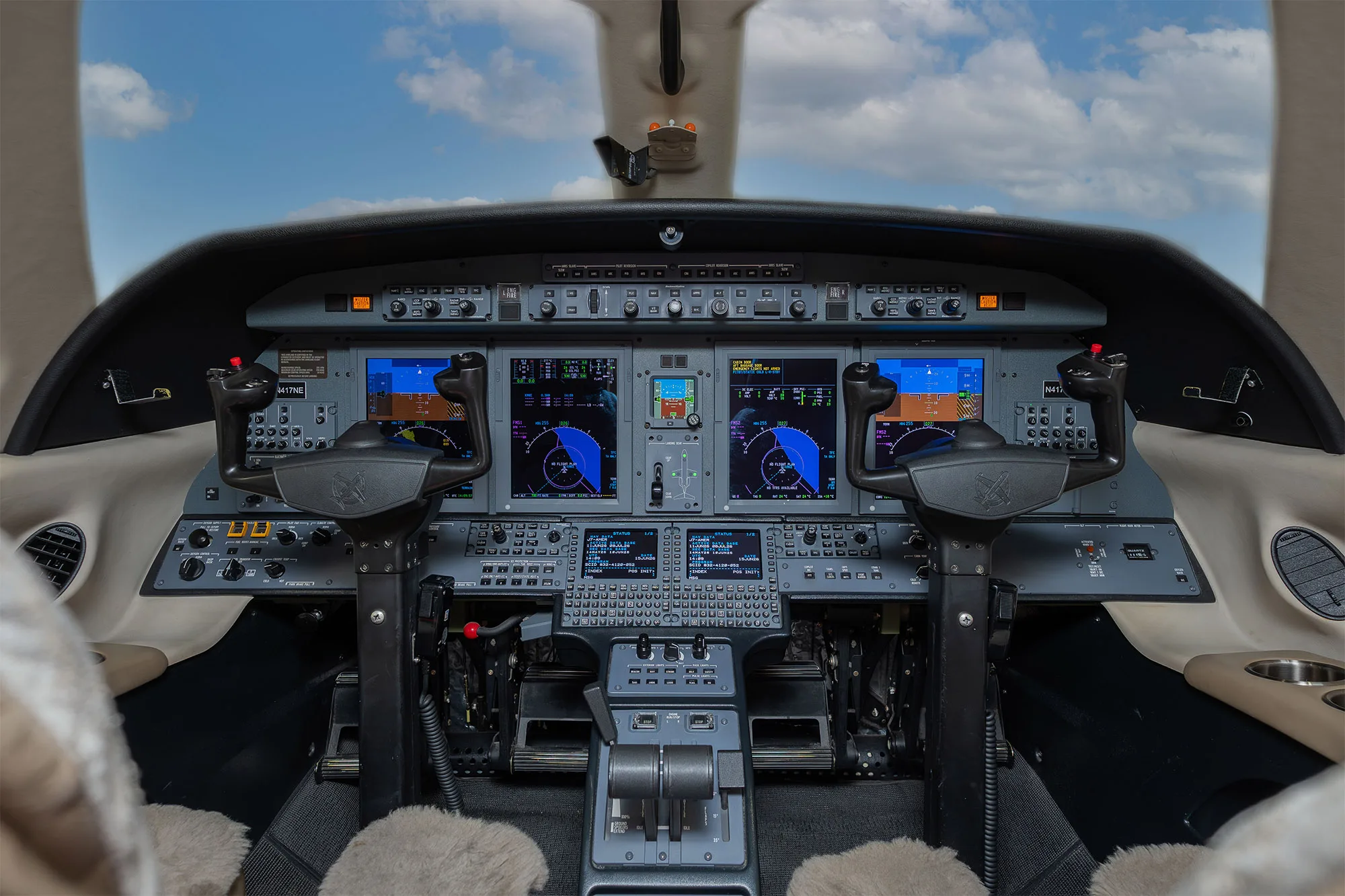 The cockpit of a business jet with multiple digital displays and control yokes.