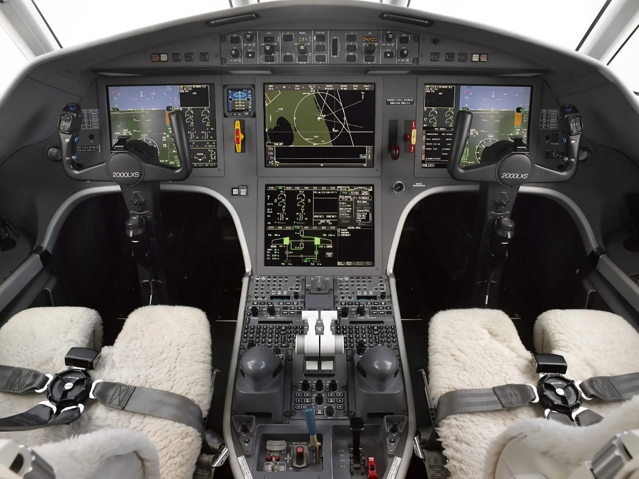 The cockpit of a Dassault Falcon 2000LXS with multiple display screens and sheepskin seat covers.
