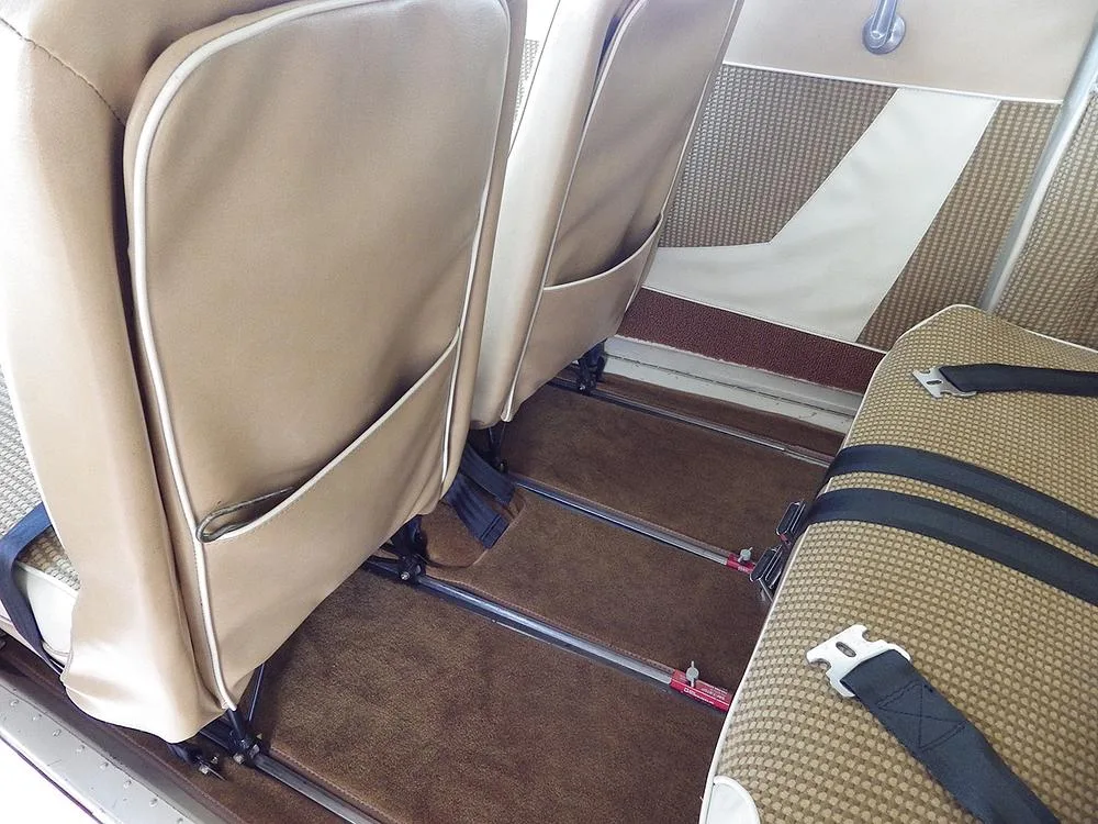 The tan and brown patterned rear cabin seats and floor of a small aircraft.