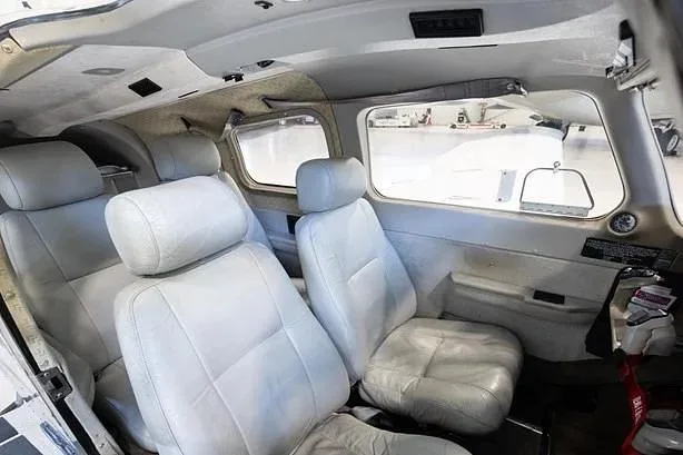The light grey leather interior cabin seats of a small aircraft.