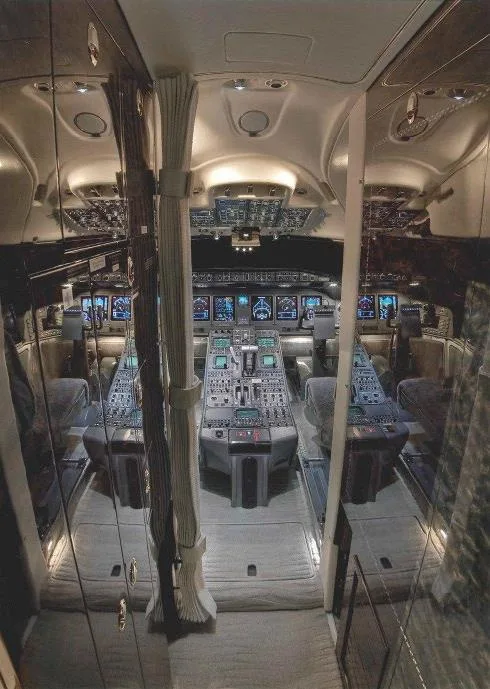The spacious cockpit of a business jet with multiple display screens and control panels.