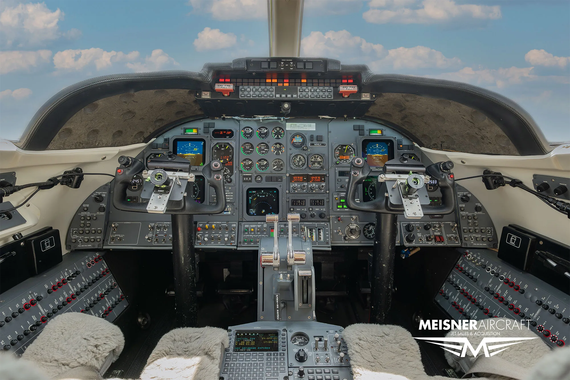 The cockpit of a private jet, showing the instrument panel, yokes, and controls.