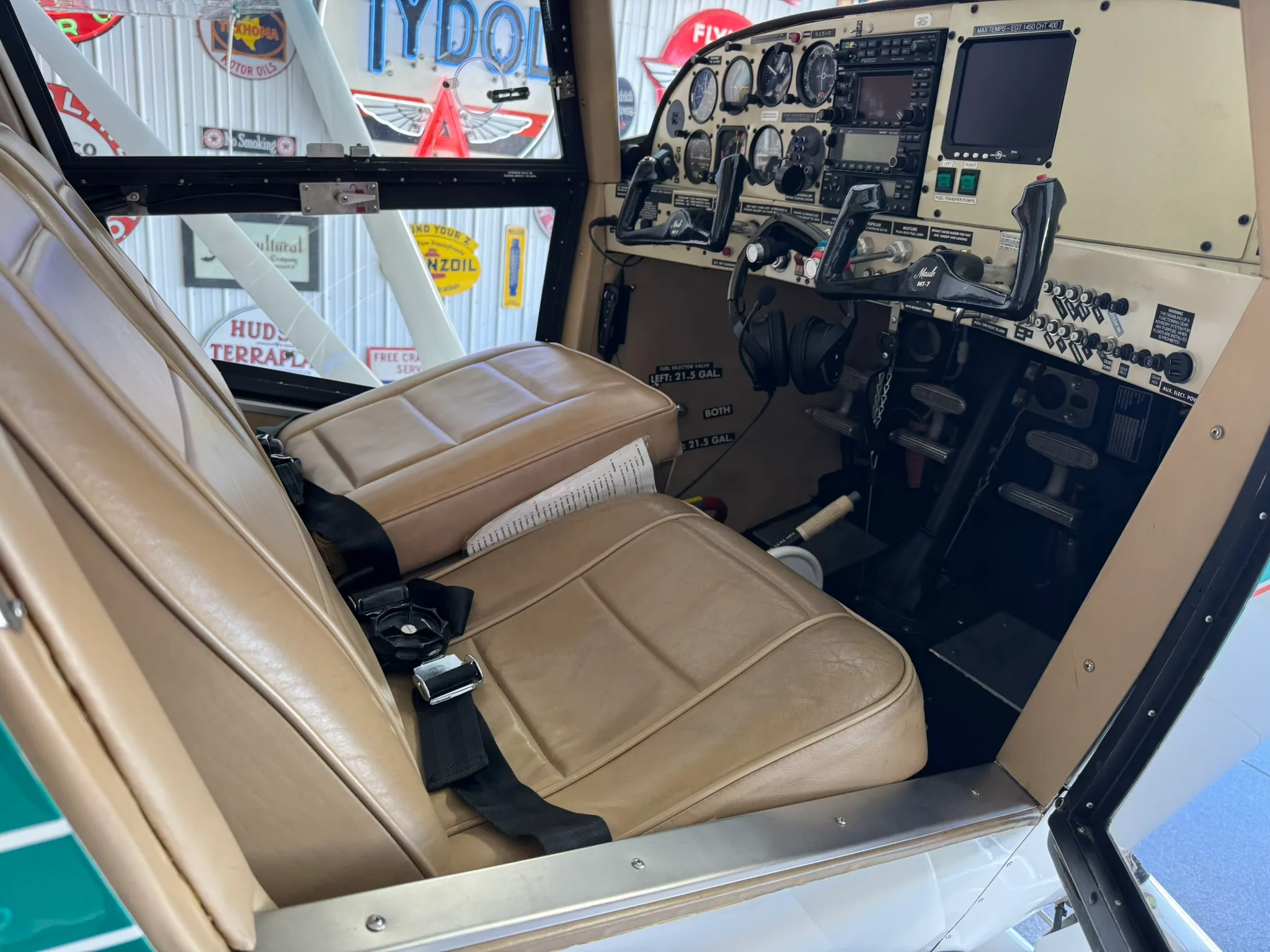 Side view of the aircraft cockpit with tan seats and instrument panel.