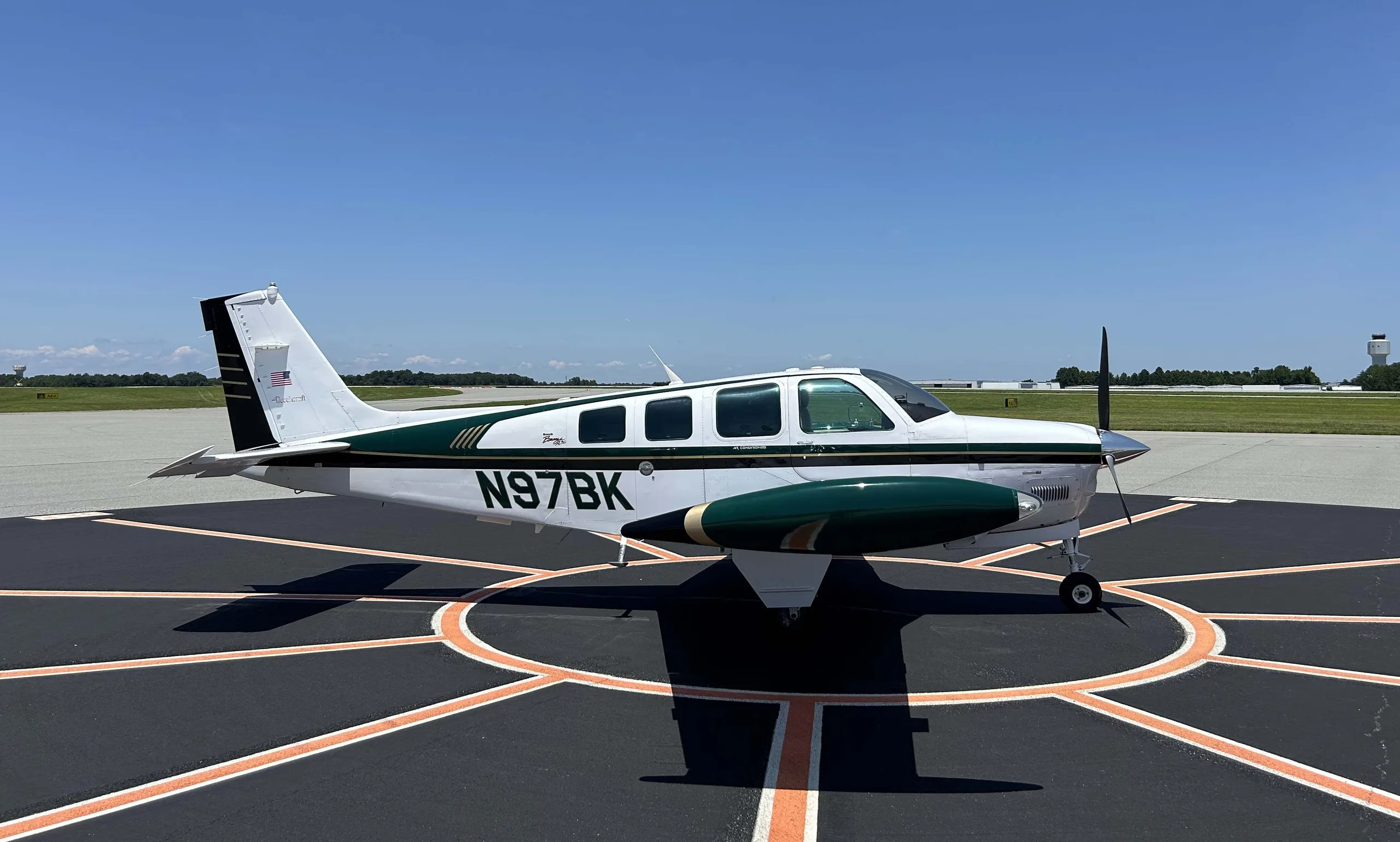 Beechcraft Baron on the tarmac with white and green paint scheme.