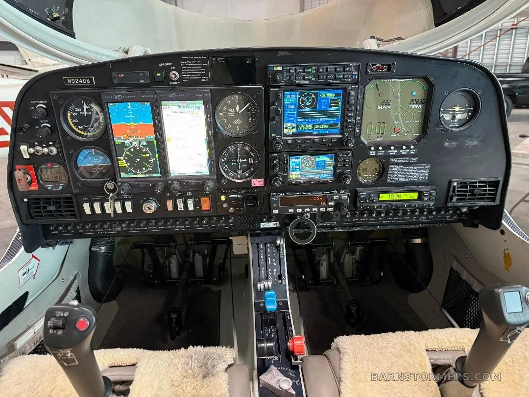 The cockpit of a Diamond DA40 aircraft, showing the instrument panel with multiple screens and controls.