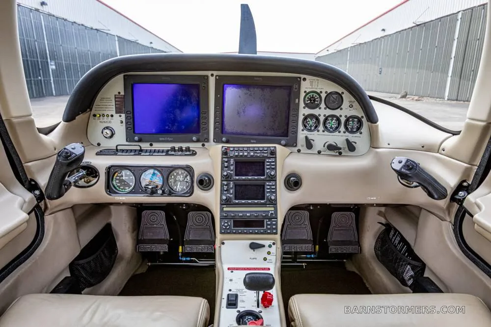 The cockpit of a Cirrus SR22 shows two large display screens, various gauges, and control yokes.