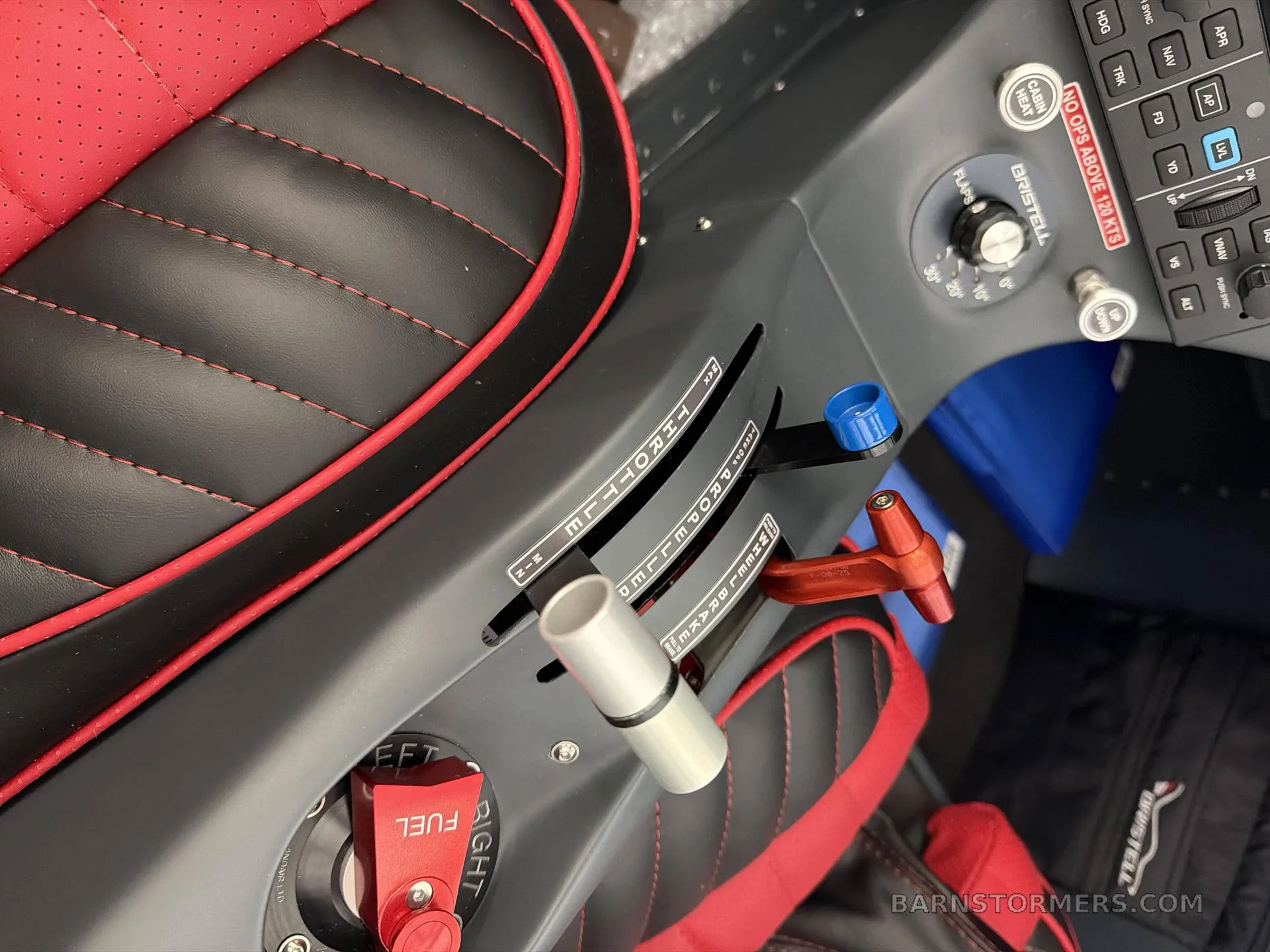 Close-up view of the throttle, propeller, and mixture levers, along with the fuel selector in a Bristell aircraft cockpit.