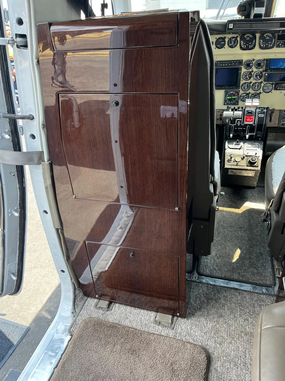 Close-up of the aircraft's cockpit, showing the wooden cabinet and instrument panel.