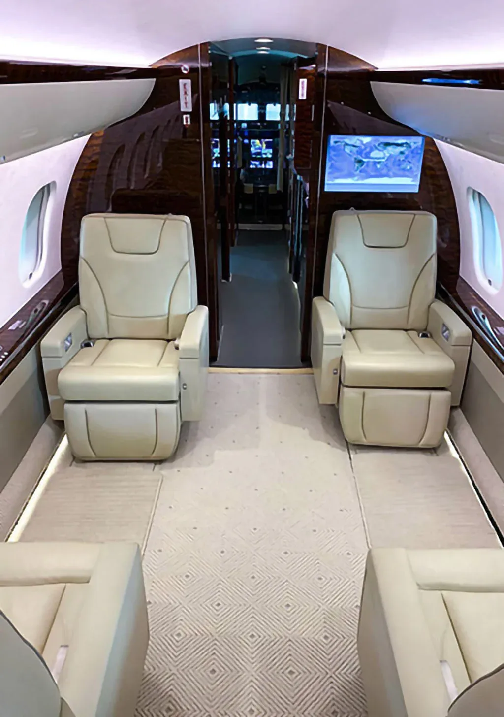 The luxurious interior of a private jet cabin features cream leather seats and dark wood paneling.
