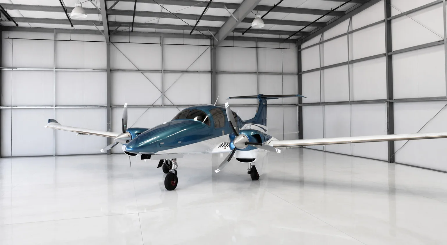 A wide front-left view of a blue and white Diamond DA62 aircraft parked in a spacious hangar.