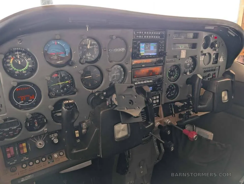 The instrument panel and controls of a small aircraft, featuring various gauges and avionics.