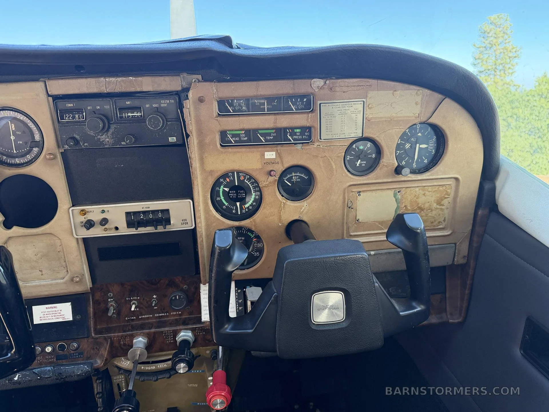 A close-up view of an aircraft's instrument panel with various gauges, radios, and a control yoke.