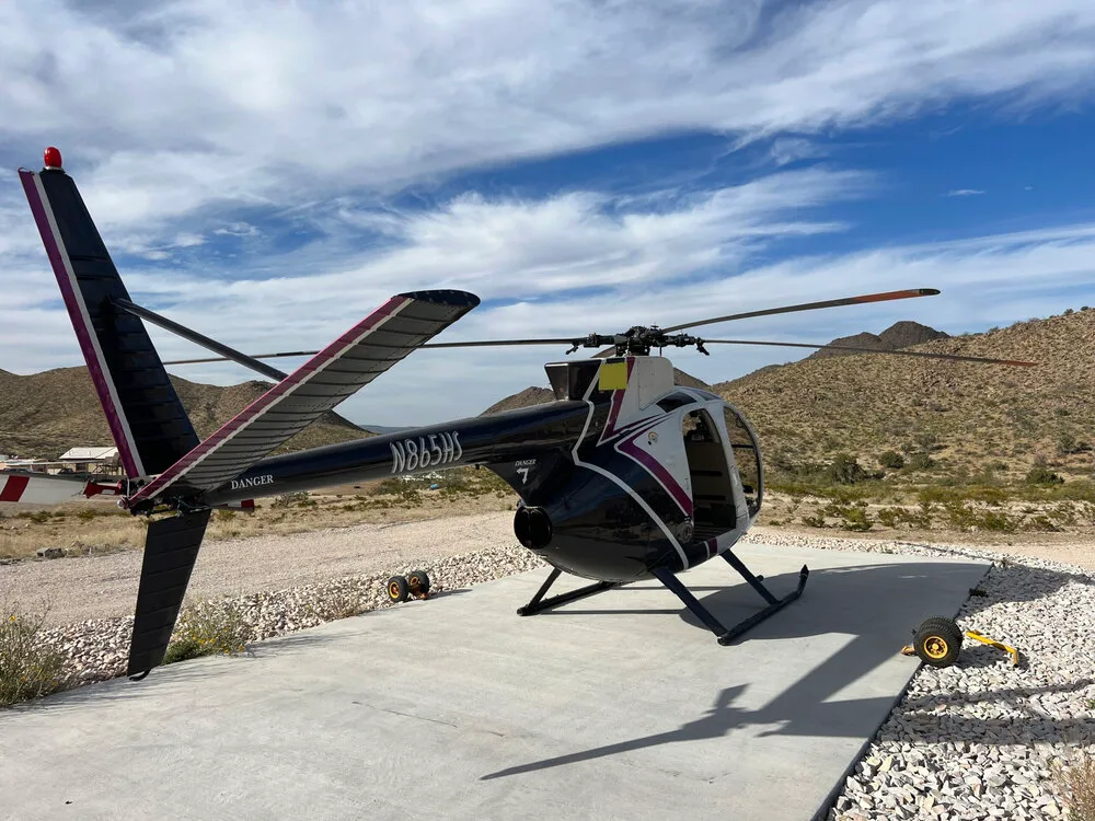 Side view of the McDonnell Douglas 500C helicopter showcasing its tail.
