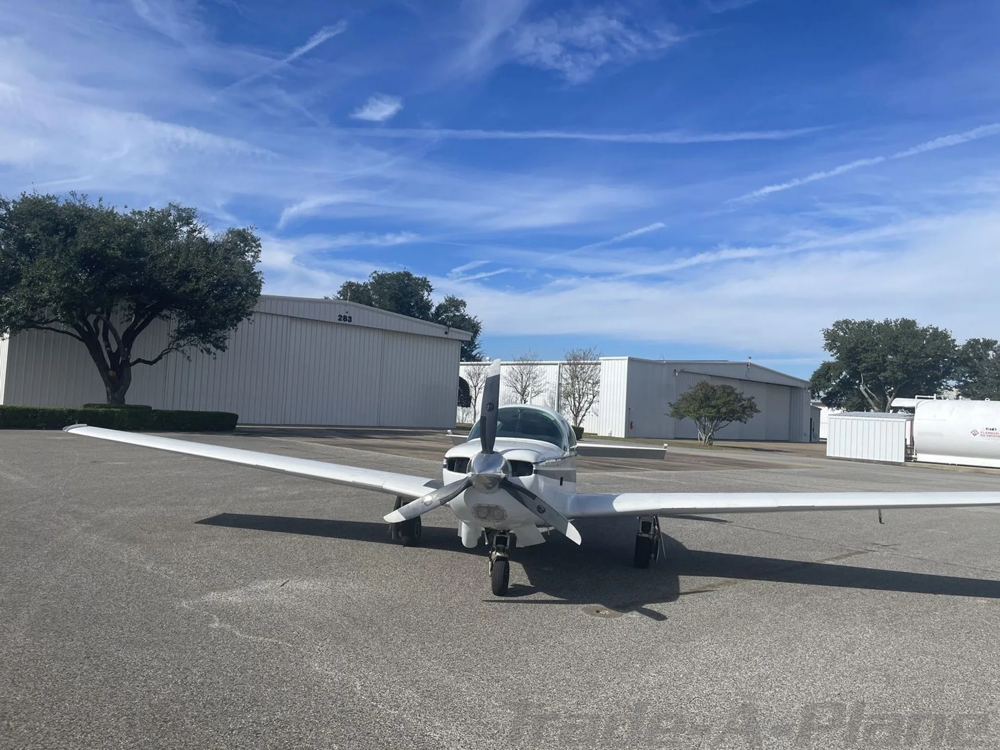 Front view of the aircraft with hangars in the background.