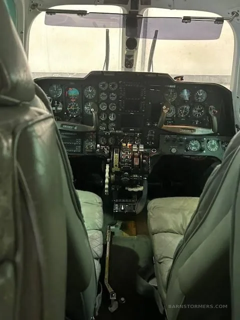 The aircraft's cockpit, viewed from the cabin, showing a complex array of analog gauges and controls.