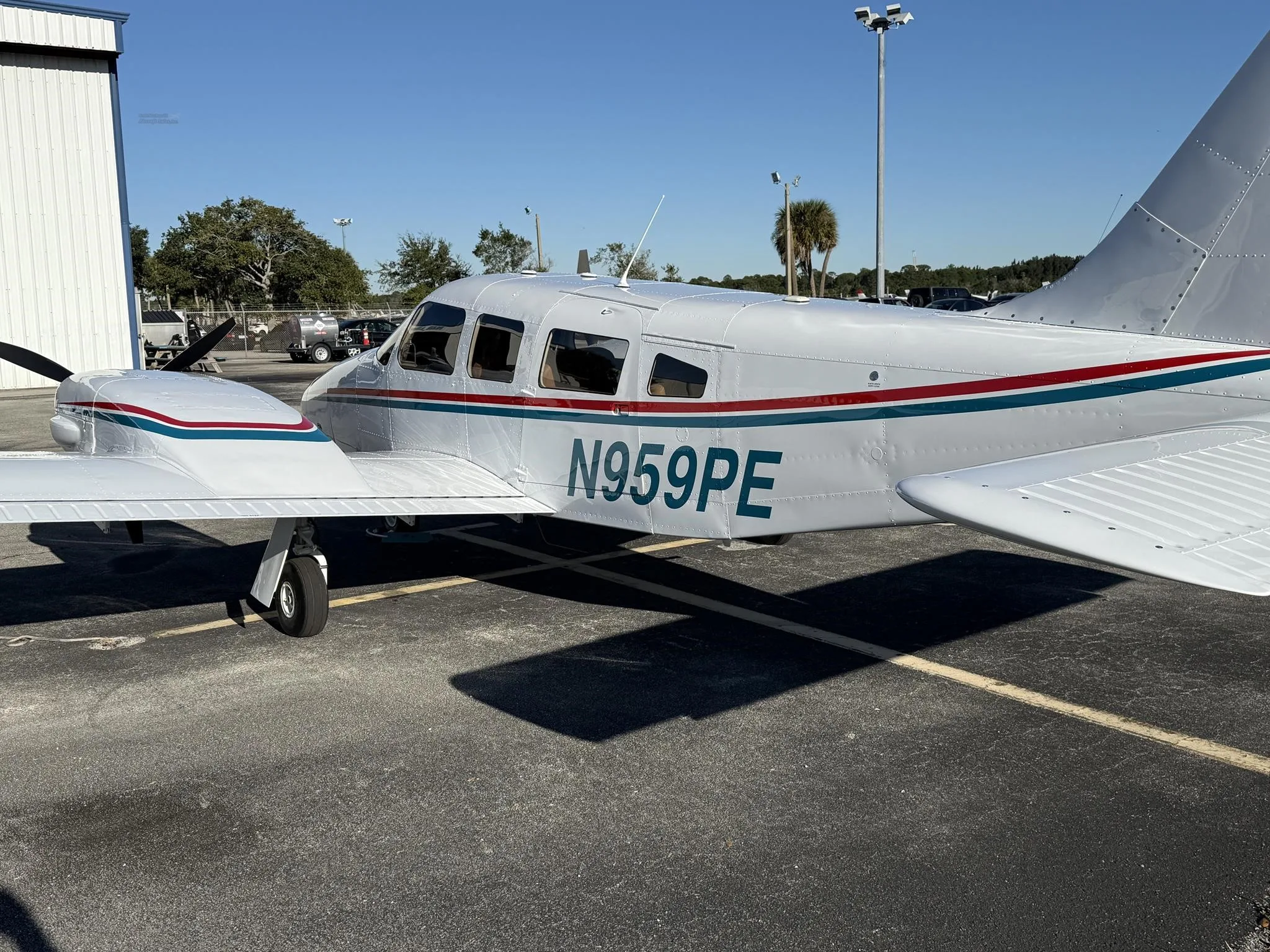 A close-up side view of the N959PE aircraft's fuselage and wing, showing the registration and paint scheme.